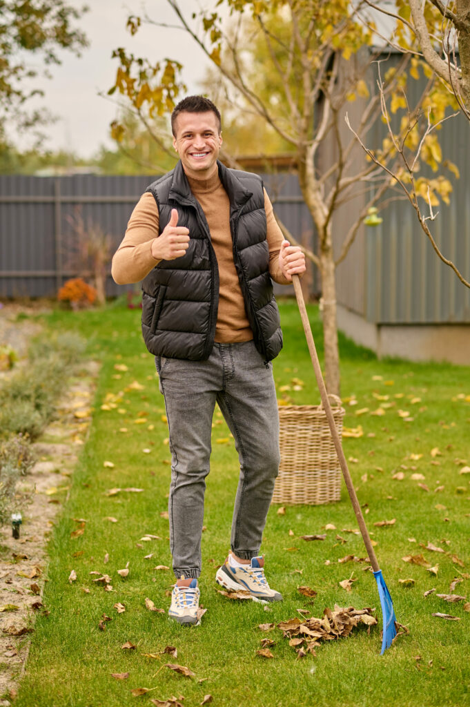 man standing with rake showing ok gesture utc