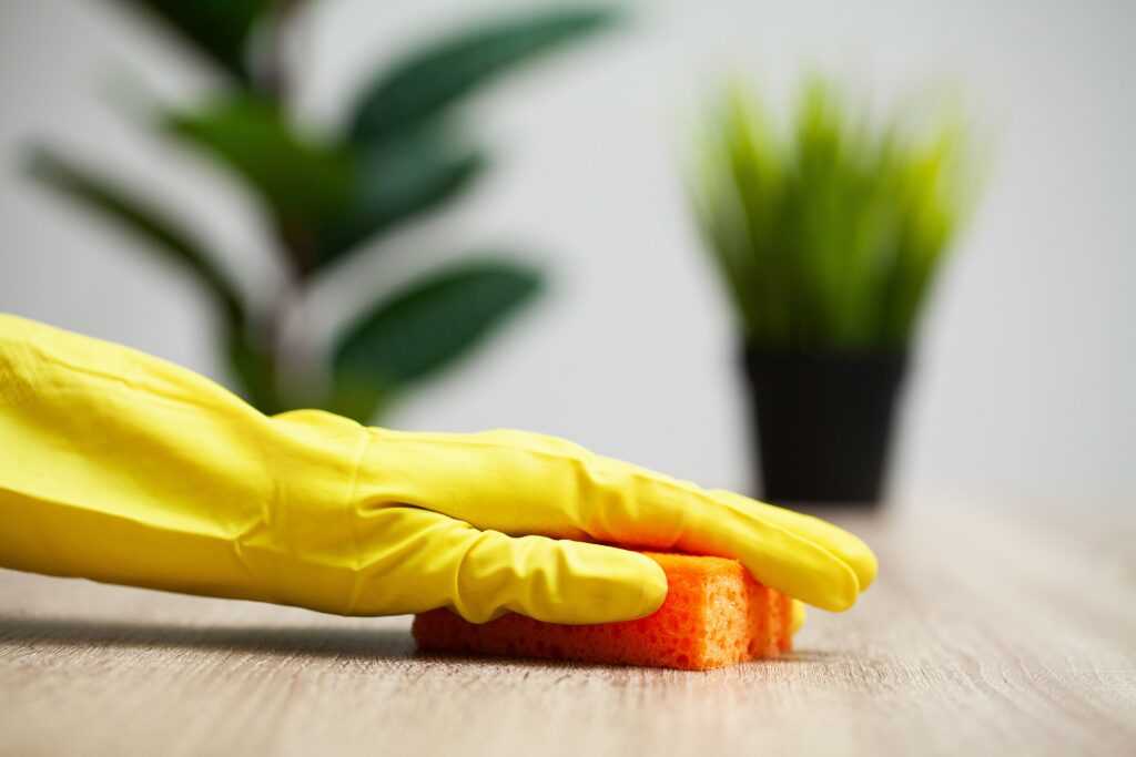 closeup-of-worker-hand-wiping-dust-in-office-min