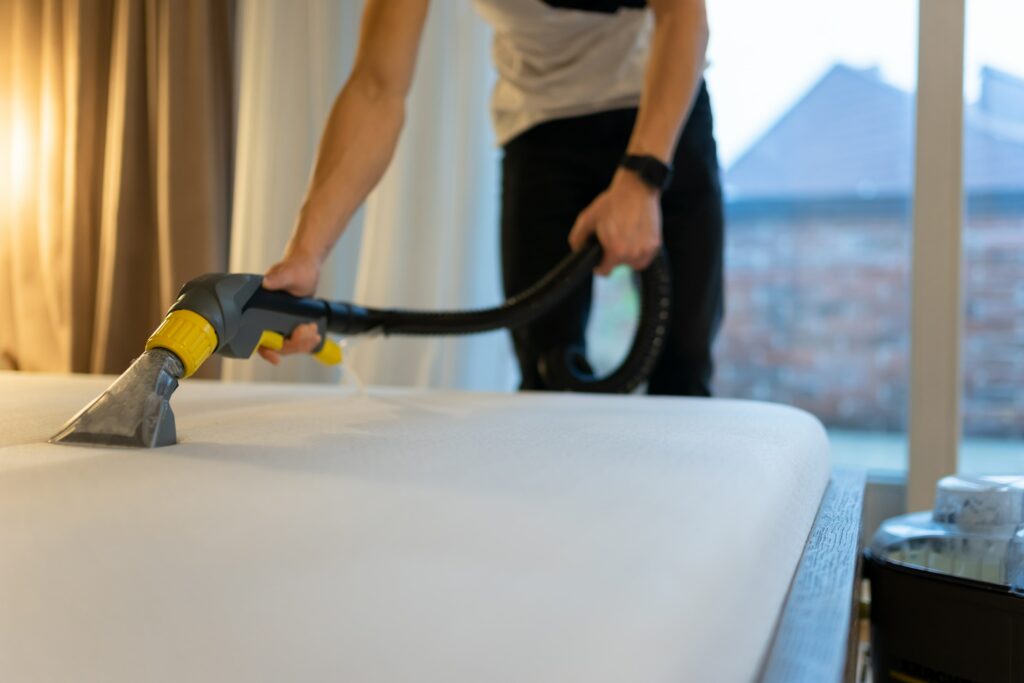 mattress-cleaning-process-man-cleans-bed-from-dir-min