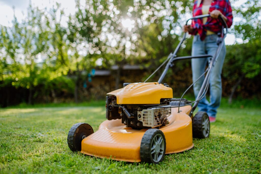 close  up  of  woman  mowing  grass  with  lawn  mower  in