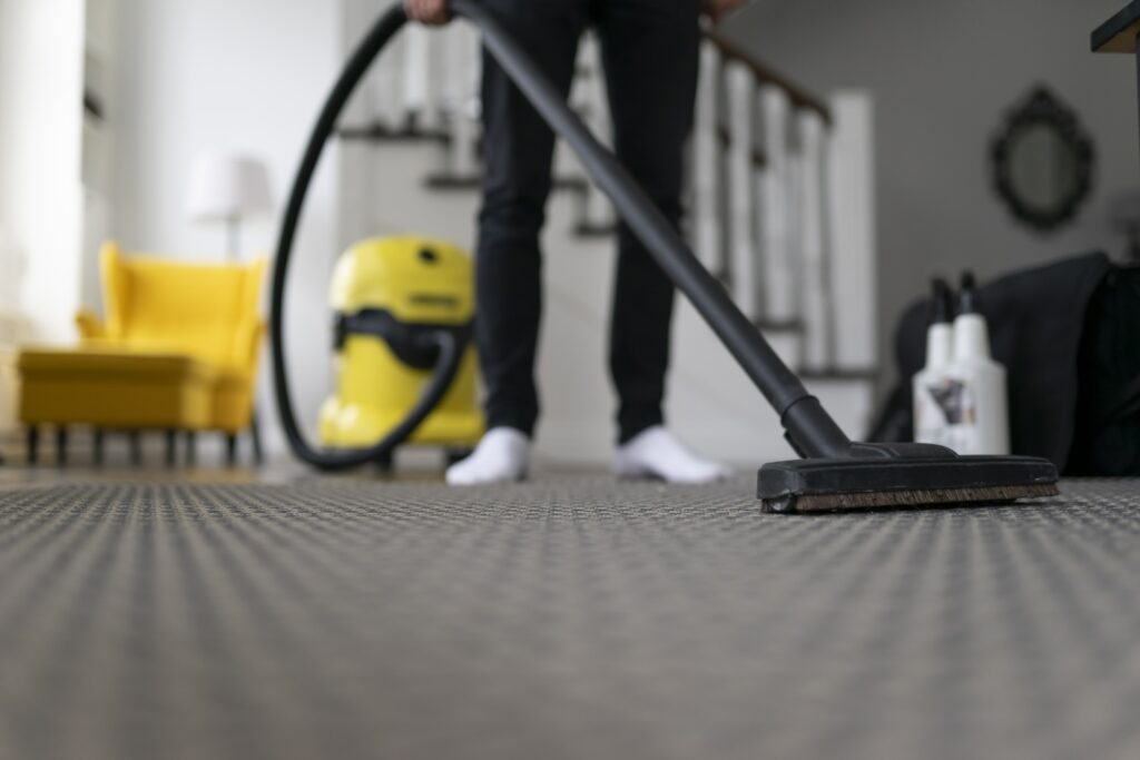 man-vacuuming-the-carpet-in-the-room-house-cleani--utc-min