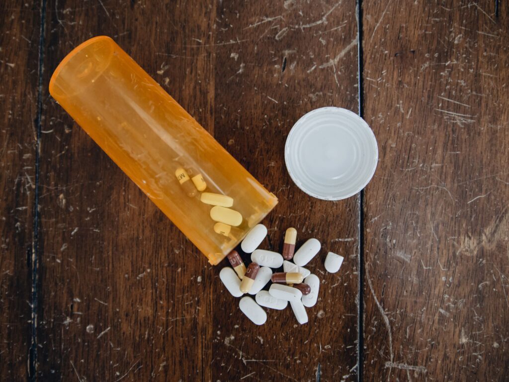 medicine pills spill out of an orange yellow plast utc min